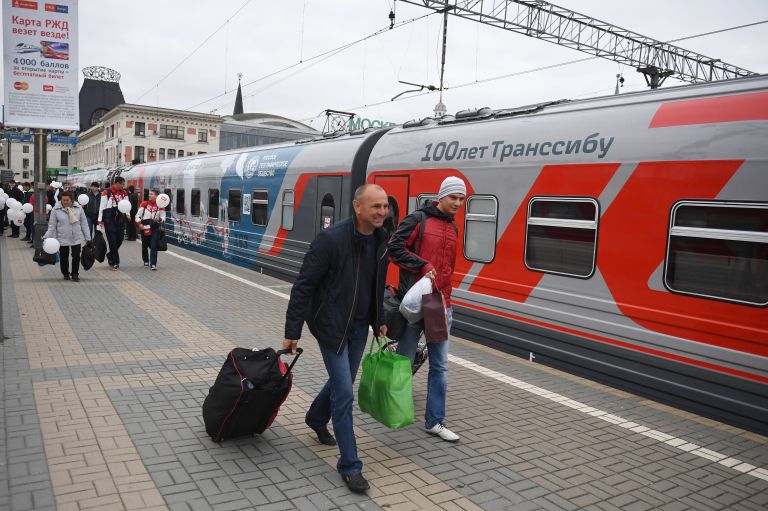 Пассажиры у поезда Россия рейса Москва – Владивосток на перроне Ярославского вокзала в Москве Пассажиры у поезда Россия рейса Москва – Владивосток на перроне Ярославского вокзала в Москве