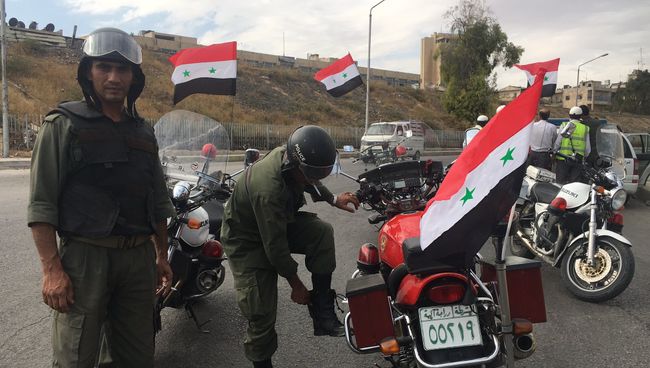 Сотрудники полиции готовятся к выходу мирных граждан и боевиков из восточного Алеппо.