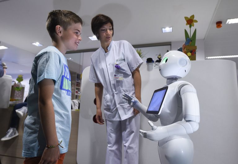 Мальчик разговаривает с роботом Pepper в городе Льеж в Бельгии Мальчик разговаривает с роботом Pepper в городе Льеж в Бельгии