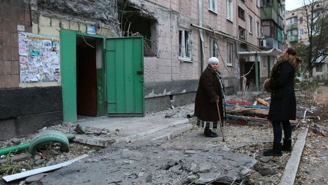 Жильцы у жилого дома, пострадавшего в результате обстрела украинскими силовиками. Архивное фото Жильцы у жилого дома, пострадавшего в результате обстрела украинскими силовиками. Архивное фото