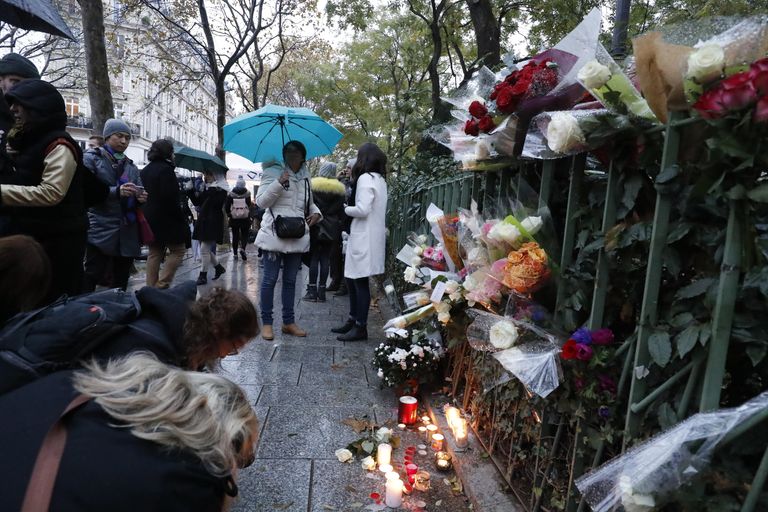 Люди приносят цветы и зажигают свечи у входа в клуб Bataclan в Париже Люди приносят цветы и зажигают свечи у входа в клуб Bataclan в Париже