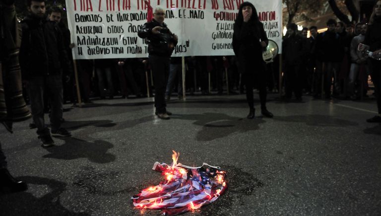 Демонстранты сжигают флаг во время акция протеста против визита президента США Барака Обамы в Афинах, Греция. 15 ноября 2016 Демонстранты сжигают флаг во время акция протеста против визита президента США Барака Обамы в Афинах, Греция. 15 ноября 2016
