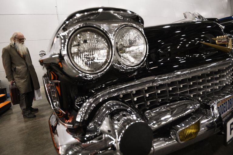 Пожилой мужчина рядом с автомобилем Cadillac