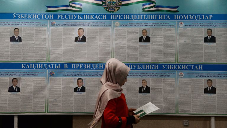 Женщина голосует на избирательном участке во время выборов президента Узбекистана