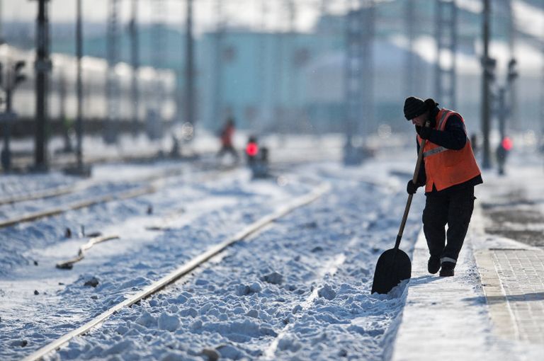 Рабочий очищает железнодорожный путь на станции Омск-Пассажирский в Омске Рабочий очищает железнодорожный путь на станции Омск-Пассажирский в Омске