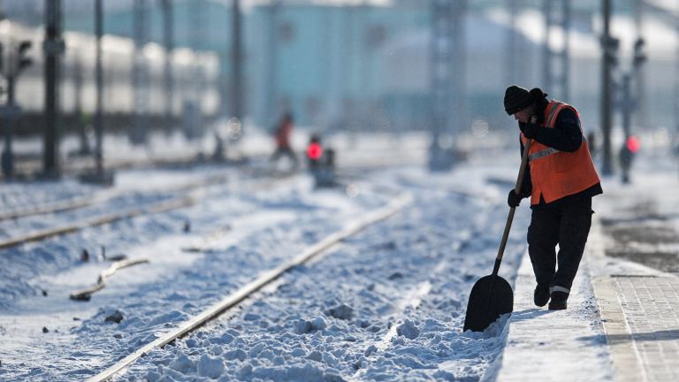 Рабочий очищает железнодорожный путь на станции Омск-Пассажирский в Омске Рабочий очищает железнодорожный путь на станции Омск-Пассажирский в Омске
