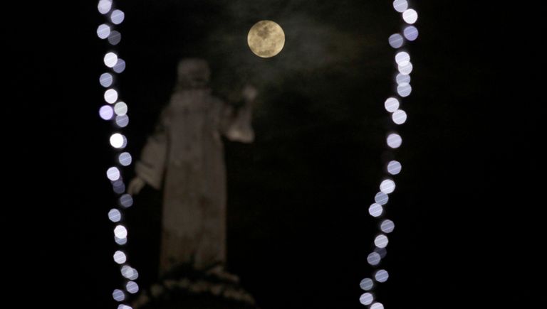 Памятник Спаситель Мира на фоне полнолуния в Сан-Сальвадоре, Сальвадор Памятник Спаситель Мира на фоне полнолуния в Сан-Сальвадоре, Сальвадор
