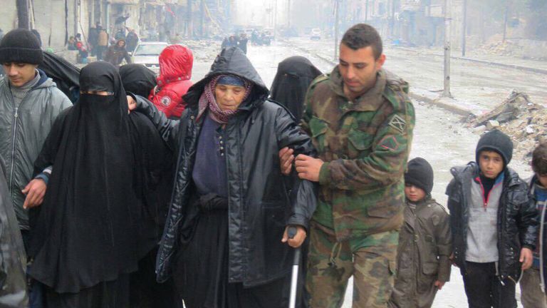 Сирийский военный и жители в восточном Алеппо