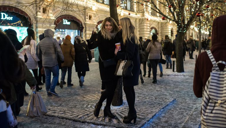 Девушки фотографируются на ГУМ-Ярмарке на Красной площади в Москве Девушки фотографируются на ГУМ-Ярмарке на Красной площади в Москве