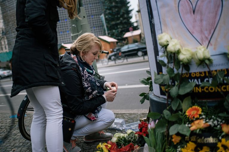 Девушка зажигает свечу недалеко от места теракта в Берлине. 20 декабря 2016 Девушка зажигает свечу недалеко от места теракта в Берлине. 20 декабря 2016