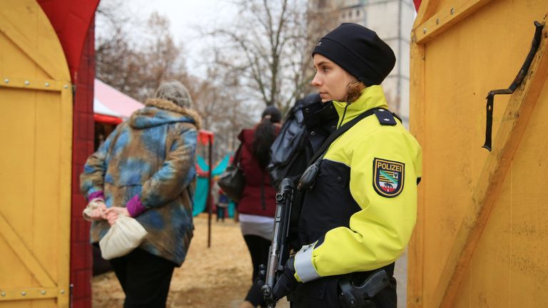Сотрудница полиции охраняет вход на рождественскую ярмарку в Магдебург, Германия Сотрудница полиции охраняет вход на рождественскую ярмарку в Магдебург, Германия
