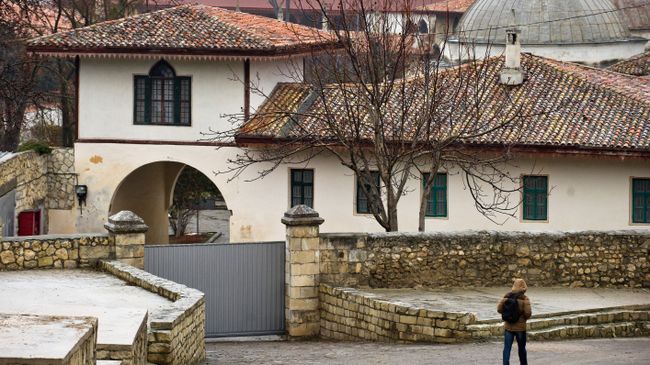 Прохожий идет по Историческому переулку вдоль Ханского дворца в Бахчисарае. Архивное фото Прохожий идет по Историческому переулку вдоль Ханского дворца в Бахчисарае. Архивное фото