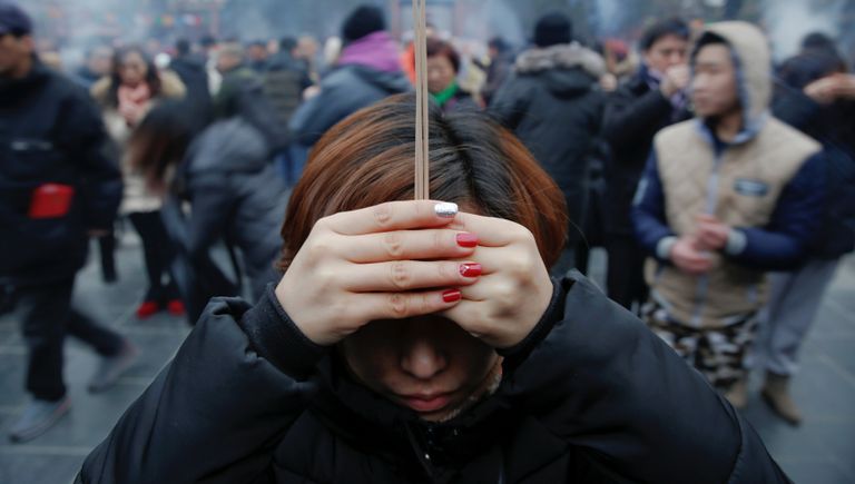 Люди молются в храме Юнхэгун Лама в первый день китайского Нового Года в Пекине, Китай. 28 января 2017 года Люди молются в храме Юнхэгун Лама в первый день китайского Нового Года в Пекине, Китай. 28 января 2017 года