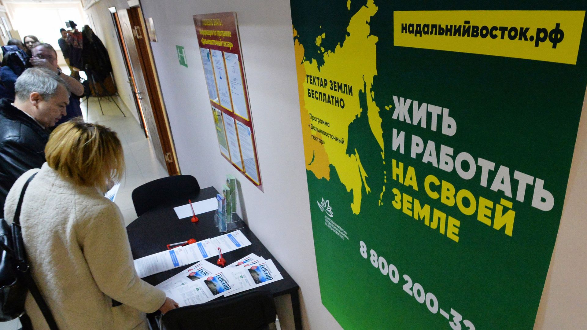 Посетители возле стенда с информационными буклетами в коридоре Департамента имущественных и земельных отношений Приморского края, где проходит вручение сертификатов на дальневосточные гектары Посетители возле стенда с информационными буклетами в коридоре Департамента имущественных и земельных отношений Приморского края, где проходит вручение сертификатов на дальневосточные гектары - РИА Новости, 1920, 08.12.2020