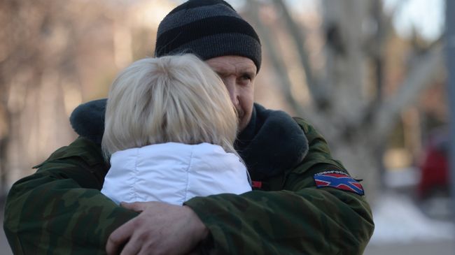 Женщина прощается с ополченцем ДНР перед отправкой автобусов с беженцами из Донецка в Россию