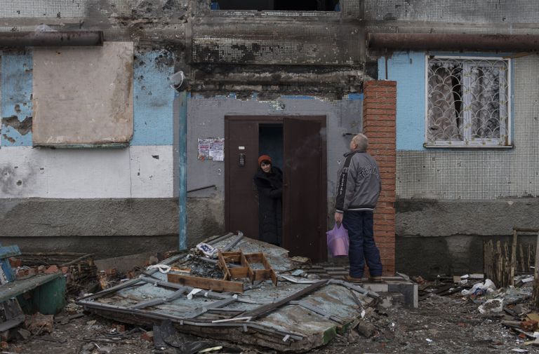 Жители Донецка у подъезда дома, поврежденного в результате обстрелов Жители Донецка у подъезда дома, поврежденного в результате обстрелов