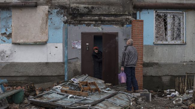 Жители Донецка у подъезда дома, поврежденного в результате обстрелов. Архивное фото Жители Донецка у подъезда дома, поврежденного в результате обстрелов. Архивное фото