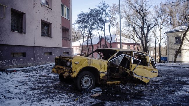 Автомобиль, поврежденный в результате обстрелов, в Киевском районе Донецка Автомобиль, поврежденный в результате обстрелов, в Киевском районе Донецка