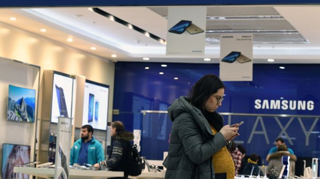 Женщина у фирменного магазина в Москве по продаже электроники корпорации Samsung Electronics Женщина у фирменного магазина в Москве по продаже электроники корпорации Samsung Electronics