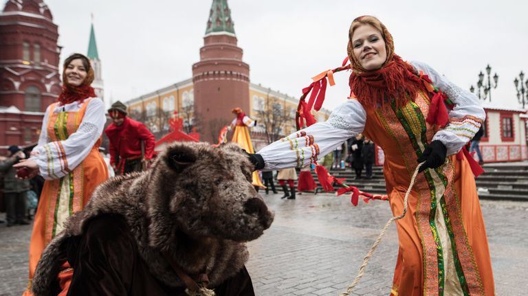 Участницы анимационной программы, одетые в праздничные костюмы, с актером в костюме медведя во время открытия фестиваля Московская масленица на Манежной площади Участницы анимационной программы, одетые в праздничные костюмы, с актером в костюме медведя во время открытия фестиваля Московская масленица на Манежной площади