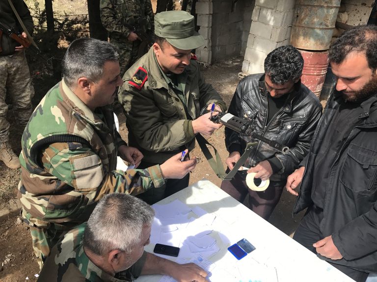 Боевики сдают сирийской армии личное оружие в рамках программы народного примирения в городе Сергая в пригороде Дамска