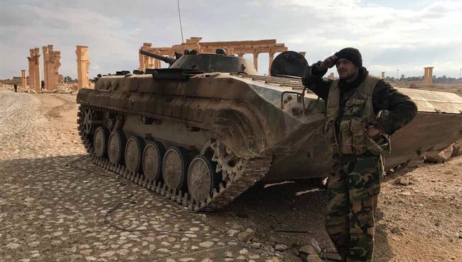 Сирийский военный возле историко-архитектурного комплекса Древней Пальмиры в сирийской провинции Хомс. Архивное фото Сирийский военный возле историко-архитектурного комплекса Древней Пальмиры в сирийской провинции Хомс. Архивное фото