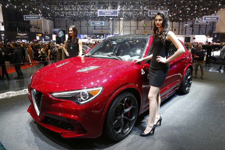 Модели позируют возле автомобиля Alfa Romeo Stelvio на Женевском международном автосалоне Модели позируют возле автомобиля Alfa Romeo Stelvio на Женевском международном автосалоне