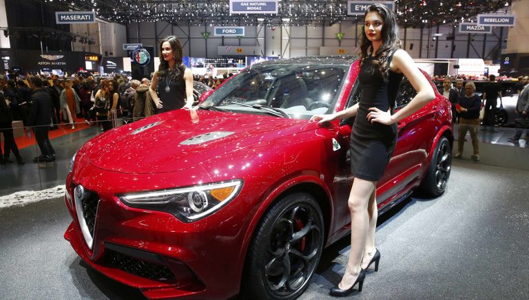 Модели позируют возле автомобиля Alfa Romeo Stelvio на Женевском международном автосалоне Модели позируют возле автомобиля Alfa Romeo Stelvio на Женевском международном автосалоне
