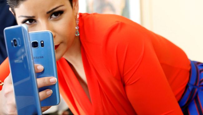 Девушка фотографирует смартфон Samsung Galaxy S8 + с Galaxy S7 на презентации в Нью-Йорке Девушка фотографирует смартфон Samsung Galaxy S8 + с Galaxy S7 на презентации в Нью-Йорке