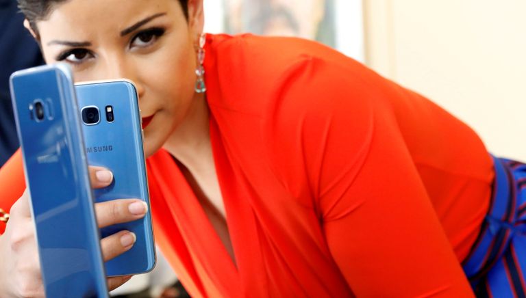Девушка фотографирует смартфон Samsung Galaxy S8 + с Galaxy S7 на презентации в Нью-Йорке
