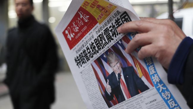 Мужчина в Китае читает газету с новостью об избрании Дональда Трампа президентом США. Архивное фото Мужчина в Китае читает газету с новостью об избрании Дональда Трампа президентом США. Архивное фото