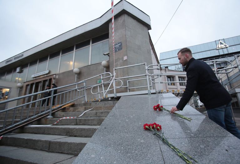 Мужчина возлагает цветы у входа в вестибюль станции метро Сенная площадь в Санкт-Петербурге Мужчина возлагает цветы у входа в вестибюль станции метро Сенная площадь в Санкт-Петербурге