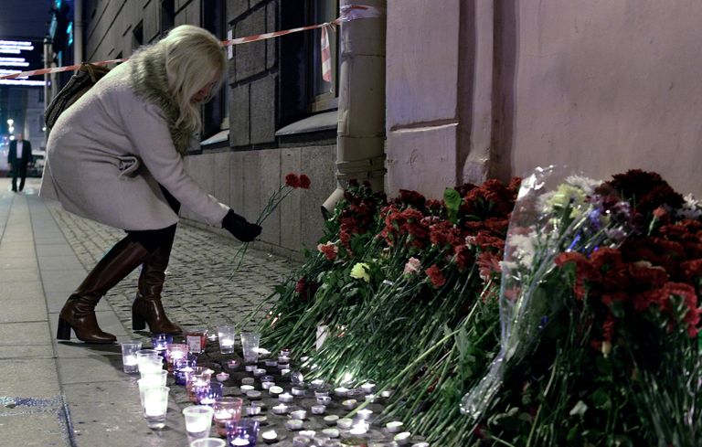 Женщина возлагает цветы рядом со станцией метро Технологический институт в память о погибших в результате взрыва в метро Санкт-Петербурга Женщина возлагает цветы рядом со станцией метро Технологический институт в память о погибших в результате взрыва в метро Санкт-Петербурга