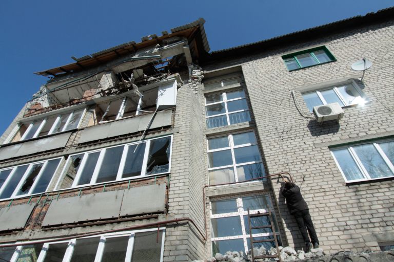 Житель пострадавшего от обстрелов многоквартирного дома на улице Привокзальной в прифронтовом поселке Донецк-Северный в Донецкой области ремонтирует газопровод Житель пострадавшего от обстрелов многоквартирного дома на улице Привокзальной в прифронтовом поселке Донецк-Северный в Донецкой области ремонтирует газопровод