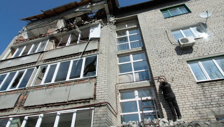 Житель пострадавшего от обстрелов многоквартирного дома на улице Привокзальной в прифронтовом поселке Донецк-Северный в Донецкой области ремонтирует газопровод Житель пострадавшего от обстрелов многоквартирного дома на улице Привокзальной в прифронтовом поселке Донецк-Северный в Донецкой области ремонтирует газопровод