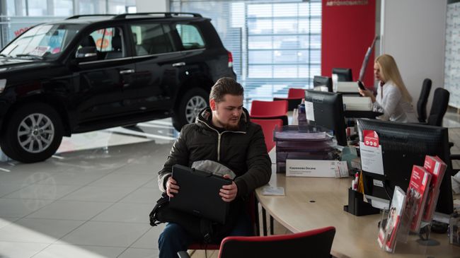 Покупка автомобиля в автосалоне. Архивное фото Покупка автомобиля в автосалоне. Архивное фото