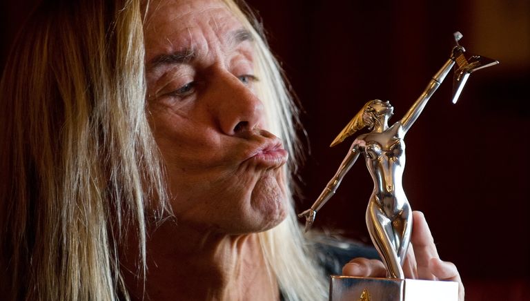 Американский певец Игги Поп позирует с премией Marshall Classic Rock Roll Honor Awards Американский певец Игги Поп позирует с премией Marshall Classic Rock Roll Honor Awards