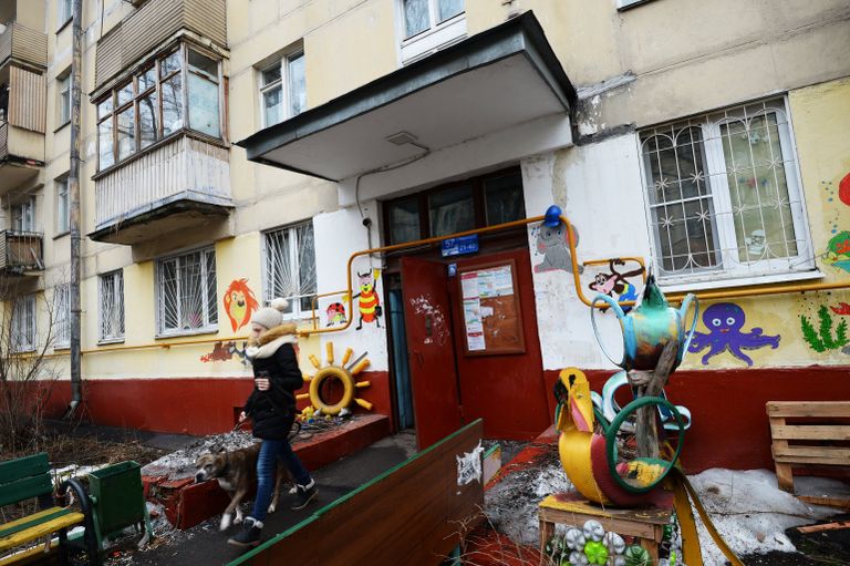 Девушка выходит с собакой из подъезда пятиэтажного жилого дома в районе Измайлово в Москве Девушка выходит с собакой из подъезда пятиэтажного жилого дома в районе Измайлово в Москве