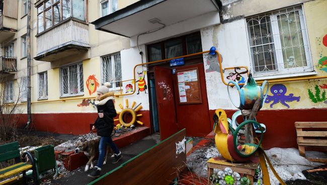 Девушка выходит с собакой из подъезда пятиэтажного жилого дома в районе Измайлово в Москве. Архивное фото Девушка выходит с собакой из подъезда пятиэтажного жилого дома в районе Измайлово в Москве. Архивное фото