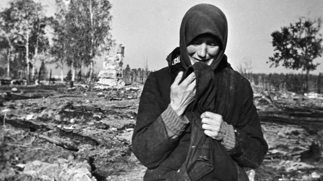 Женщина плачет на развалинах родного села, сожженного фашистами во время Великой Отечественной войны Женщина плачет на развалинах родного села, сожженного фашистами во время Великой Отечественной войны