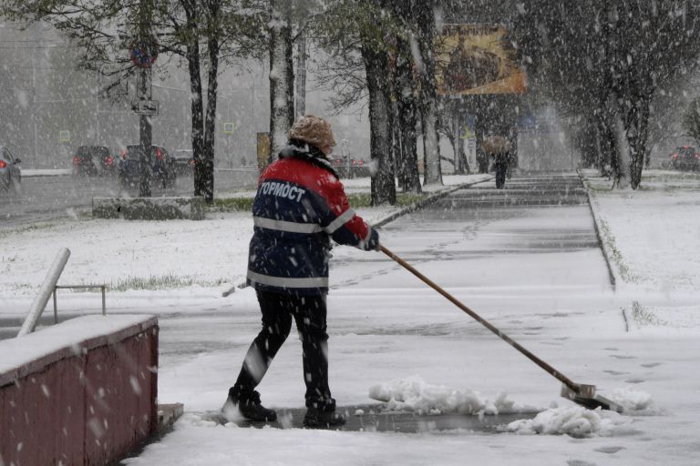 Сотрудница ГБУ Гормост убирает снег на Ленинском проспекте в Москве