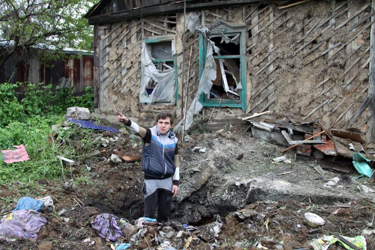 Подросток демонстрирует повреждения жилого дома, полученные в результате обстрела Куйбышевского района Донецка. 10 мая 2017