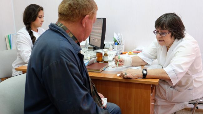 Пациент на приеме у врача в поликлинике. Архивное фото Пациент на приеме у врача в поликлинике. Архивное фото