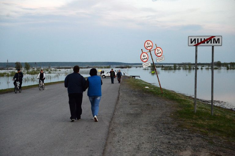 Местные жители на дороге в городе Ишим Тюменской области, подтопленной в результате сильного поднятия воды в реках Ишим и Карасуль Местные жители на дороге в городе Ишим Тюменской области, подтопленной в результате сильного поднятия воды в реках Ишим и Карасуль