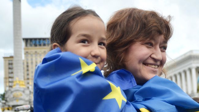 Люди с флагами ЕС и Украины на площади Независимости в Киеве. Архивное фото Люди с флагами ЕС и Украины на площади Независимости в Киеве. Архивное фото