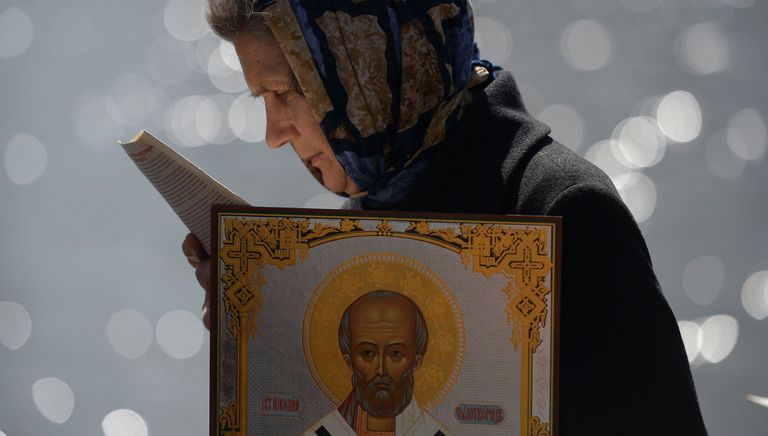 Верующая стоит в очереди к храму Христа Спасителя, где находится ковчег с мощами святителя Николая Чудотворца Верующая стоит в очереди к храму Христа Спасителя, где находится ковчег с мощами святителя Николая Чудотворца