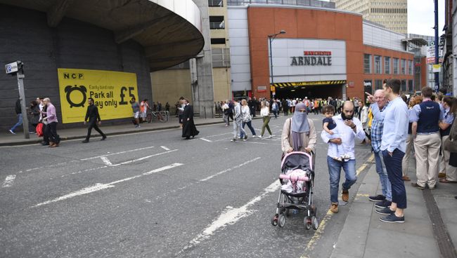 Люди покидают торговый центр Arndale в Манчестере, Великобритания Люди покидают торговый центр Arndale в Манчестере, Великобритания