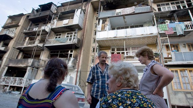 Жители Цхинвала возле своего дома, пострадавшего от пуль и снарядов в ходе обстрелов. 14 августа 2008 года Жители Цхинвала возле своего дома, пострадавшего от пуль и снарядов в ходе обстрелов. 14 августа 2008 года