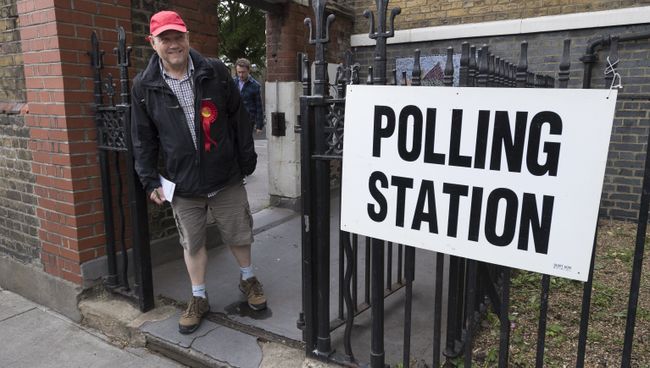 Сторонник Лейбористской партии выходит с избирательного участка в Лондоне Сторонник Лейбористской партии выходит с избирательного участка в Лондоне