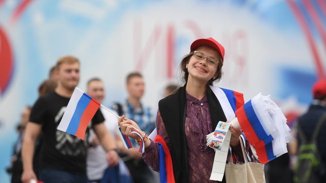 Девушка раздает флажки перед началом праздничного концерта, посвященного Дню России, на Красной площади. 12 июня 2017 Девушка раздает флажки перед началом праздничного концерта, посвященного Дню России, на Красной площади. 12 июня 2017